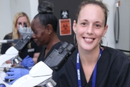 Three Healthcare Students Using Microscopes in a Lab